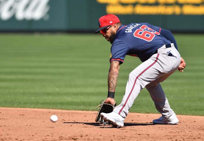 Braves infielder Leury Garcia (#63) scoops up a ground ball during a fielding drill Tuesday, Feb. 20, 2024 at CoolToday Park in North Port, Florida.  
